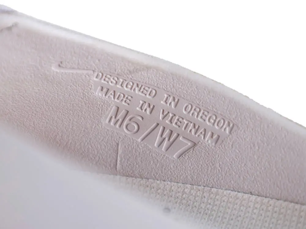 White rubber shoe sole with embossed text stating design and manufacturing details.