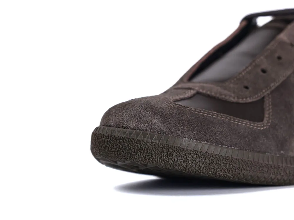 Close-up of a brown suede shoe with a textured rubber sole.