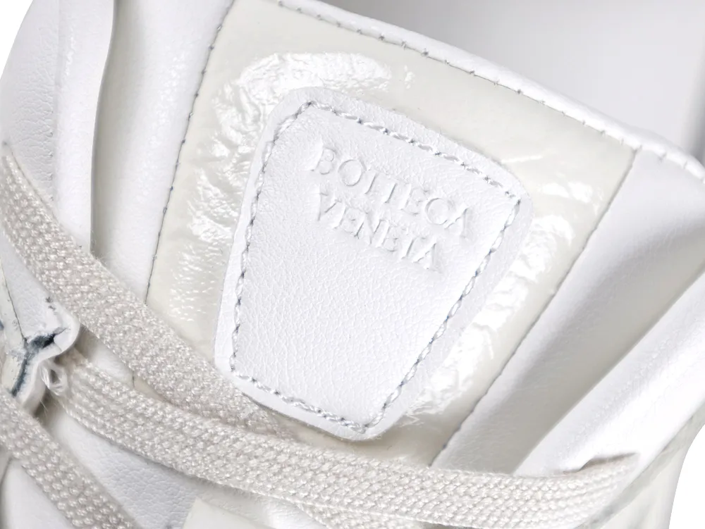 Detailed view of the white leather tongue patch with an embossed Bottega Veneta logo.