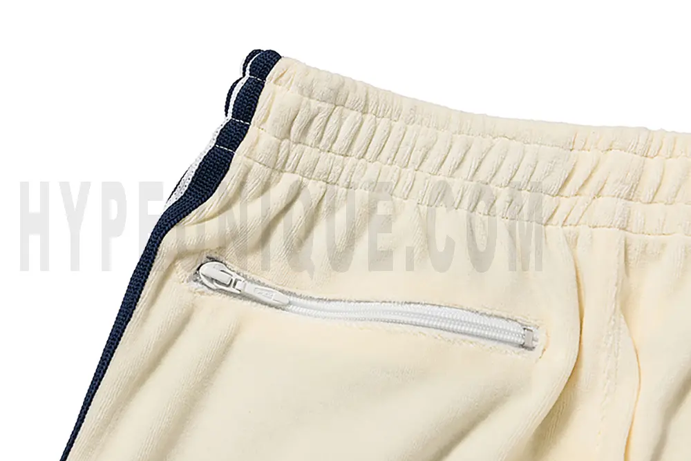 Detail of the back zip pocket on the track pants.