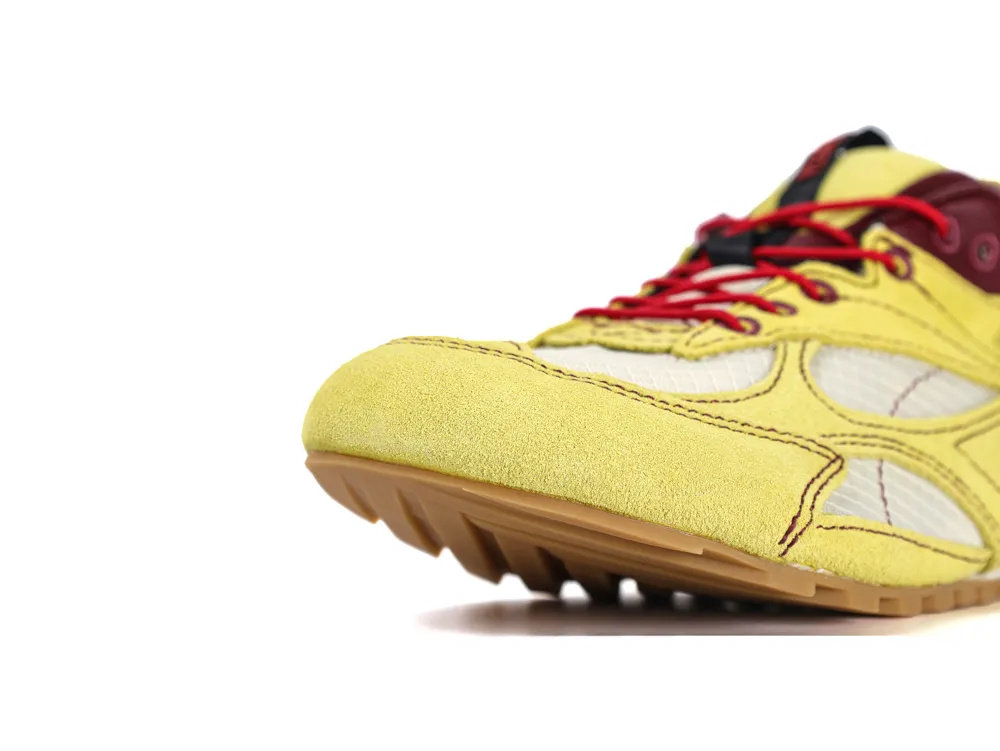 Yellow suede sneaker with burgundy and red detailing, mesh panels, and rubber sole.