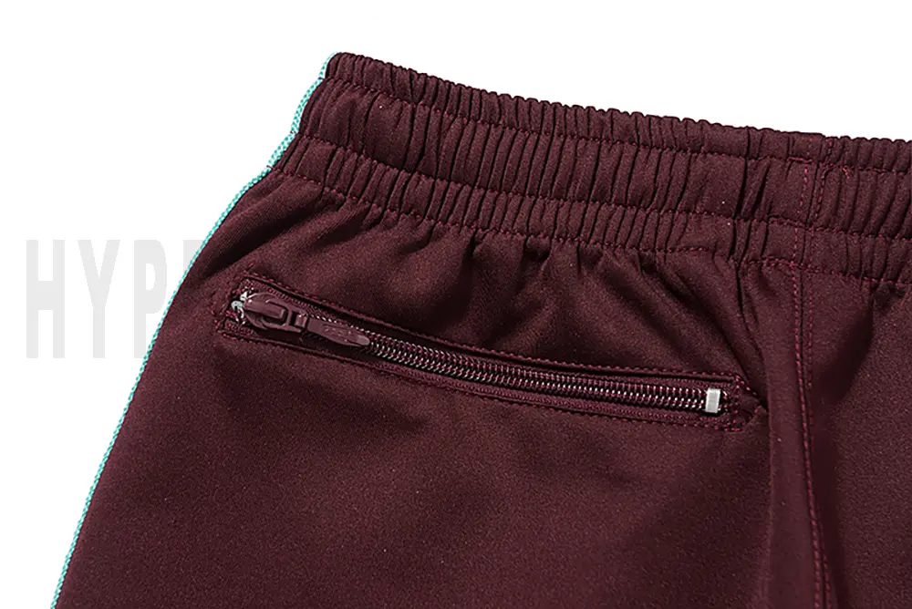Detail of the back zip pocket on the track pants.