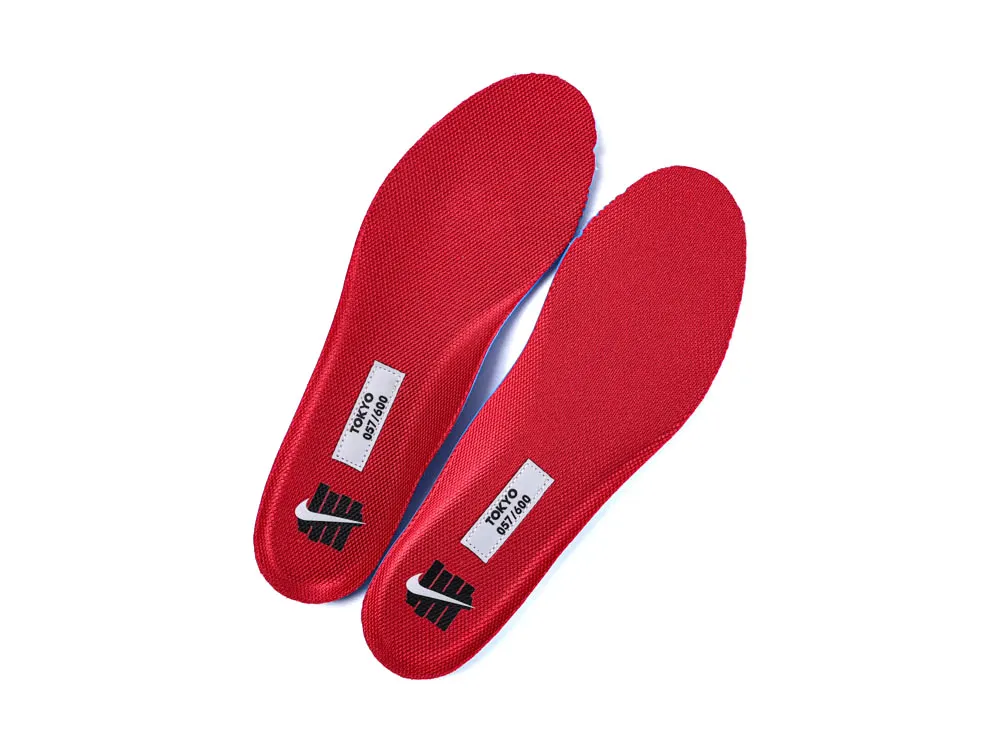 Red fabric insoles with printed labels, designed for enhanced comfort and support.