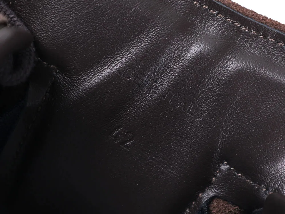 Dark brown leather interior of shoe with visible stitching and embossed text.