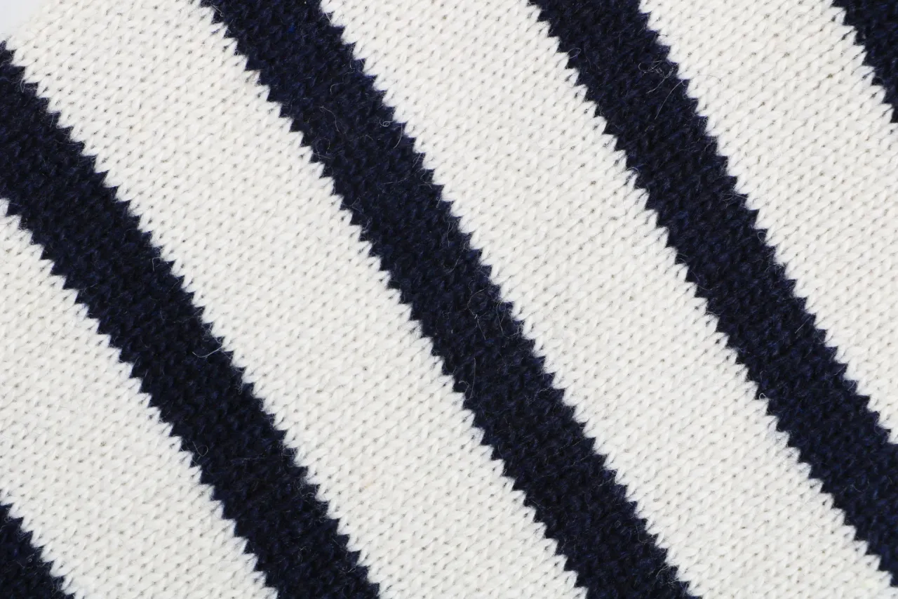 Four-bar stripe knit detail on navy cardigan sleeve
