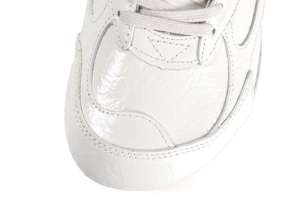 Overhead view of the rounded toe box featuring shiny cream leather and light grey laces.