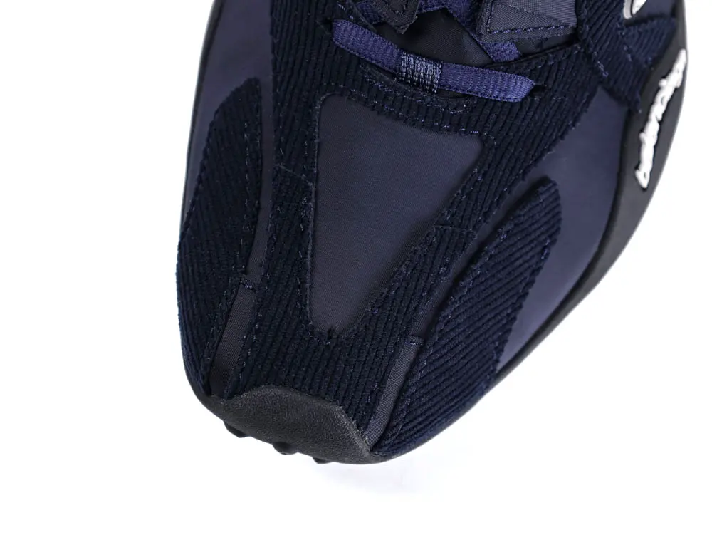 Navy blue sneaker with a mesh and suede upper, featuring a rubber sole.