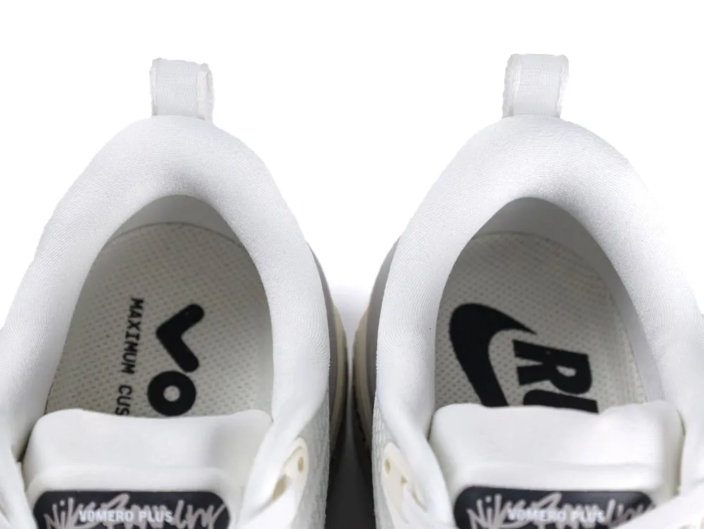 White fabric sneakers with padded interior, featuring branded insoles and pull tabs.
