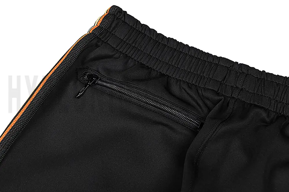Detail of the back zip pocket on the track pants.
