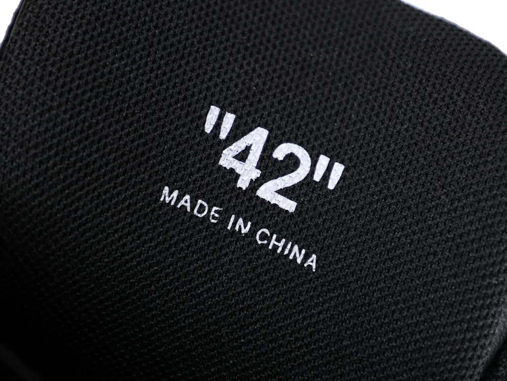 Black fabric material with "42" printed, likely part of a shoe, made in China.