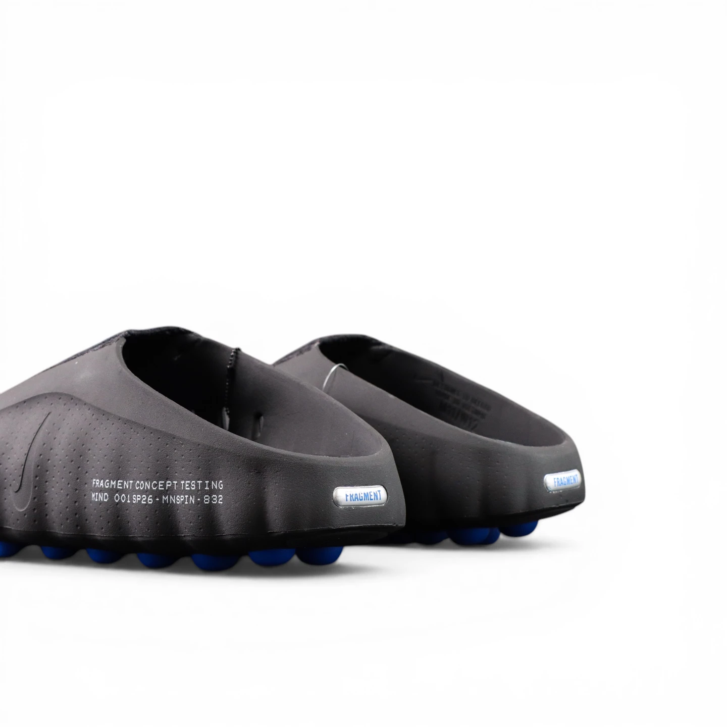 Black synthetic shoes with blue studs, viewed from the back.