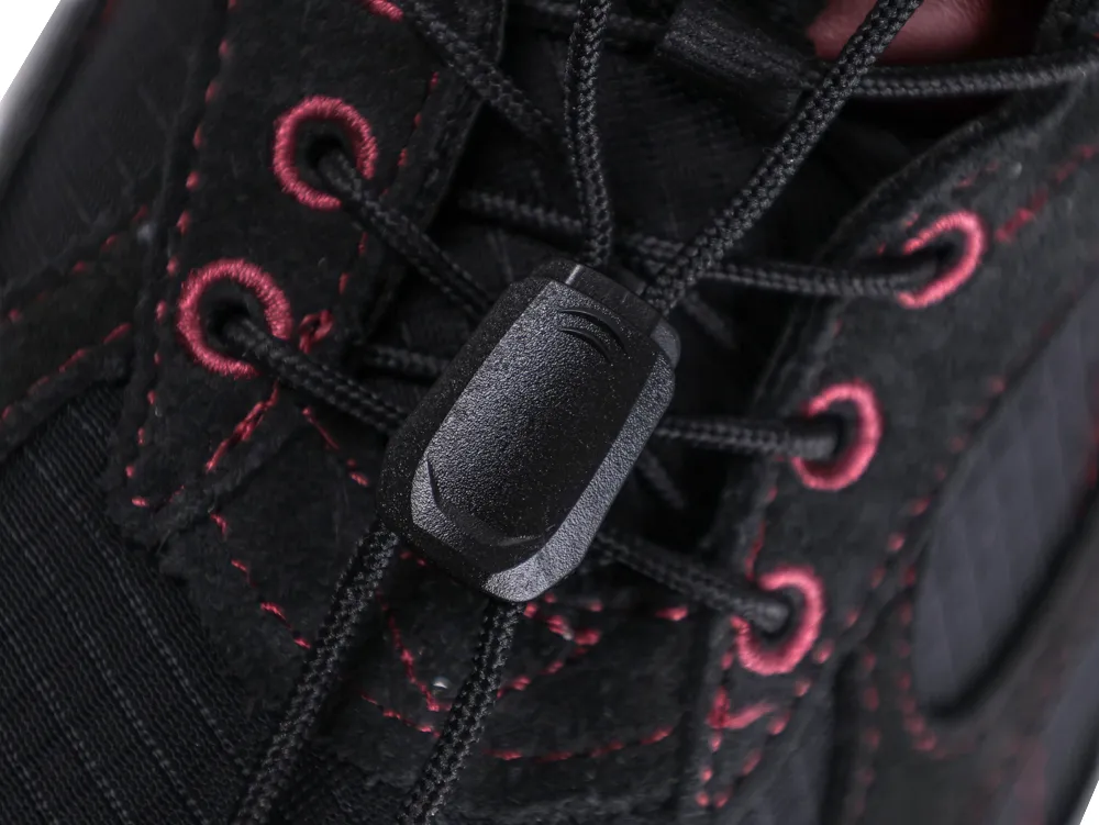 Close-up of black shoe lace system with red stitching and fabric eyelets.