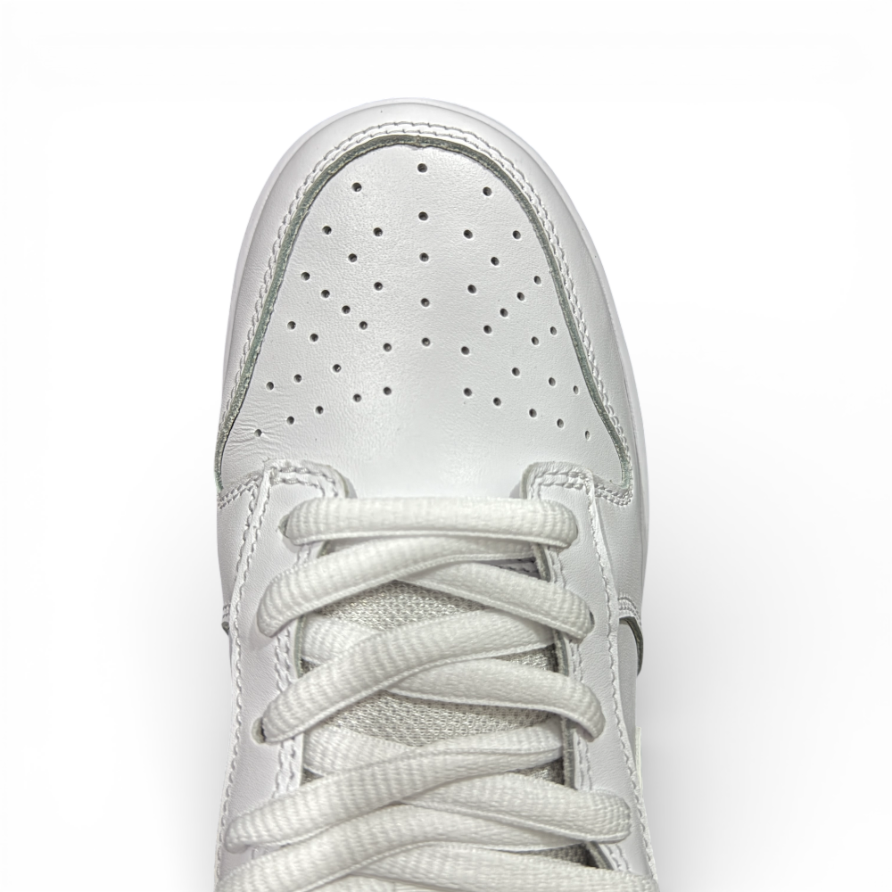 Top-down view of white sneaker toe box with evenly spaced perforations and flat laces