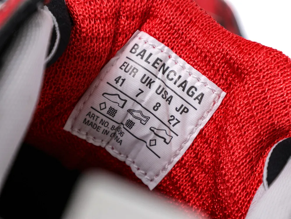 Close-up of a red fabric shoe with a white label displaying sizing information.