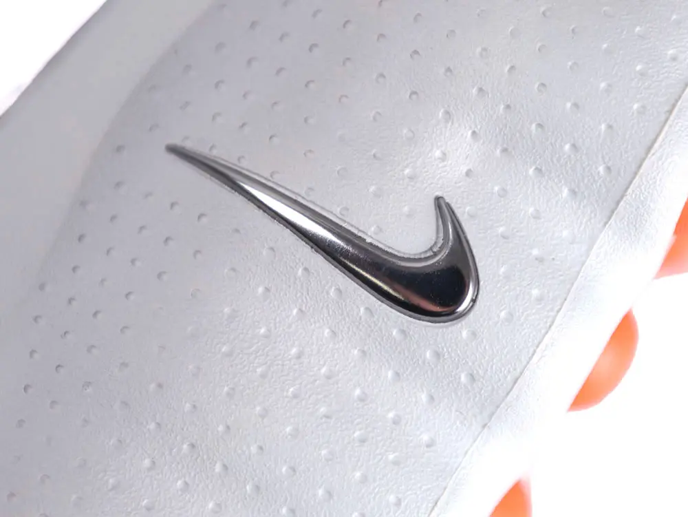 White leather shoe with metallic Swoosh logo and perforated design details.