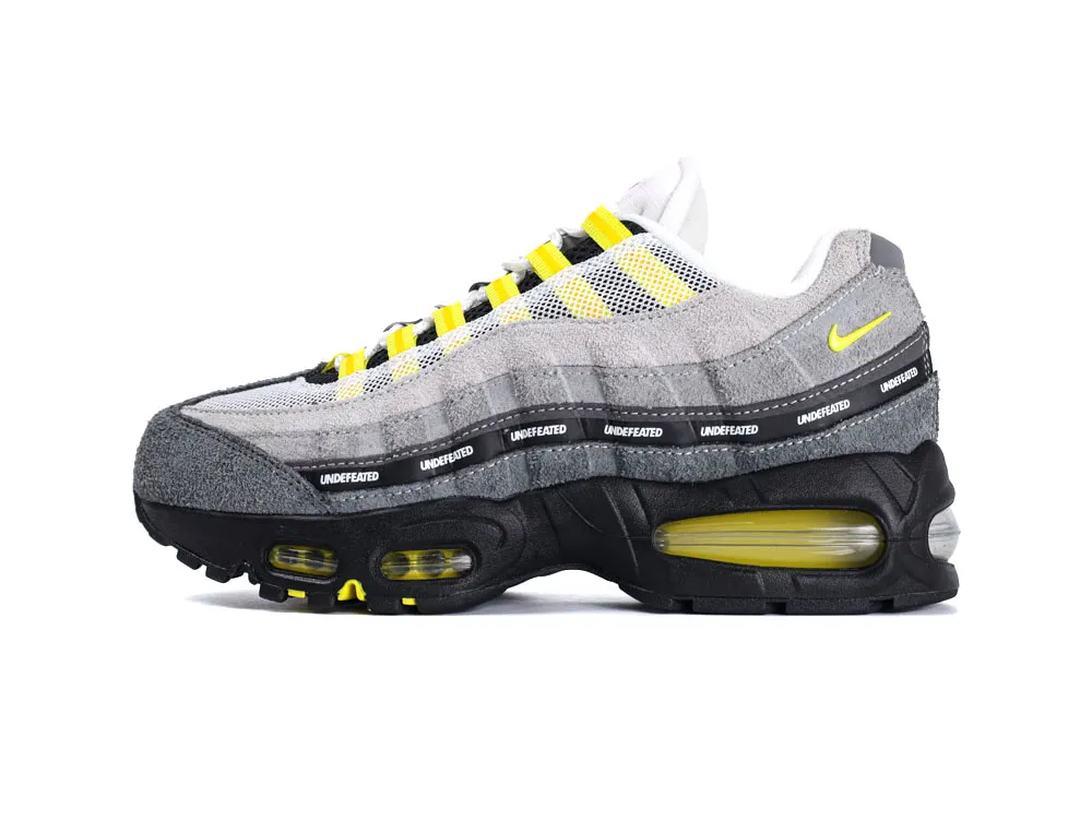 Gray suede and mesh sneaker with yellow accents and a black rubber sole.