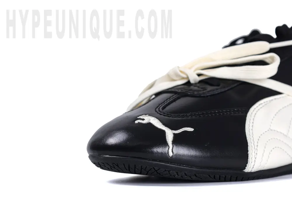 A front view of the left front of the toe box, showing the white leopard logo and the black patent leather upper.