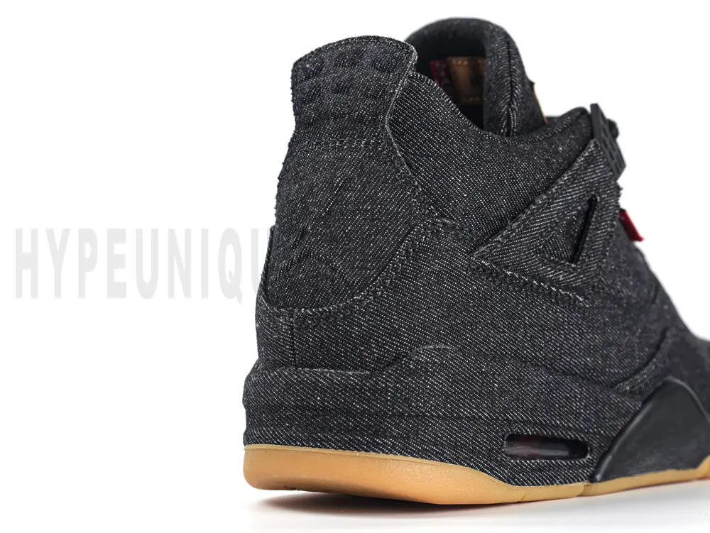 Side angle of the Air Jordan 4 Retro Levi’s Black GS, featuring black denim construction with red Levi’s tab and gum outsole.