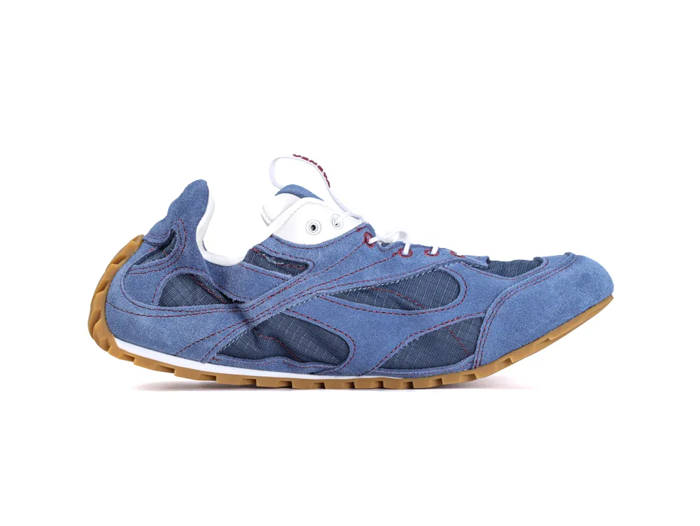 Blue suede shoe with mesh panels and brown rubber sole, featuring white laces.