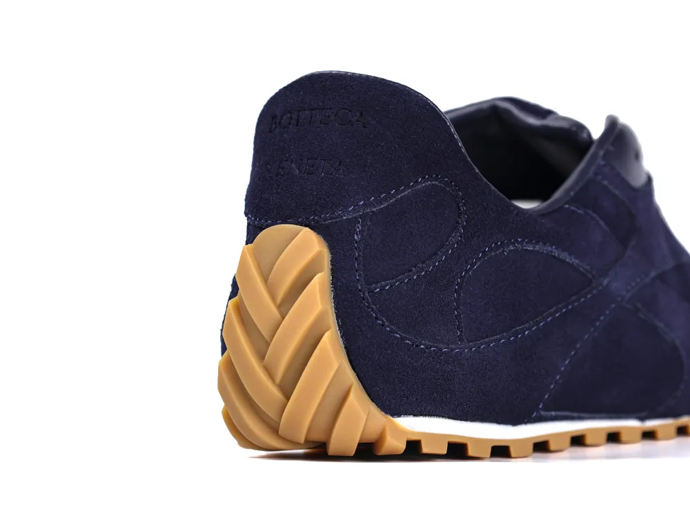 Dark blue suede shoe with a rubber sole, featuring textured tread design.
