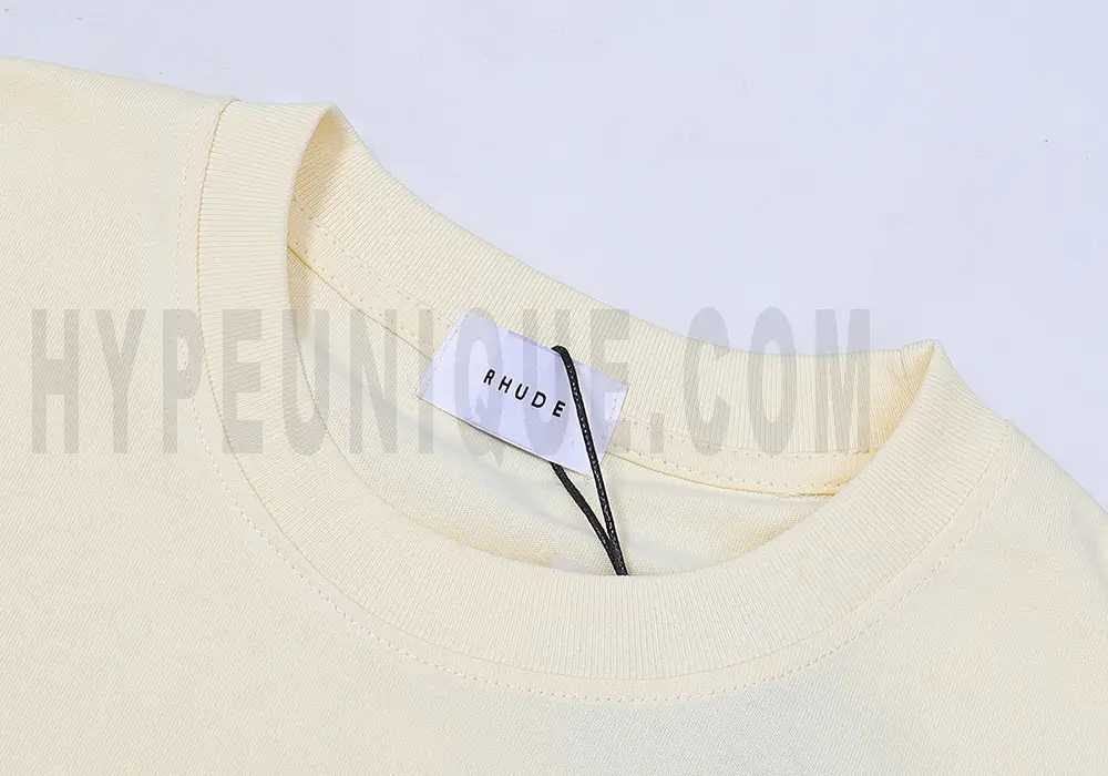 Close-up of the T-shirt's neckline tag, showcasing wash care instructions and brand details in a fashion design.