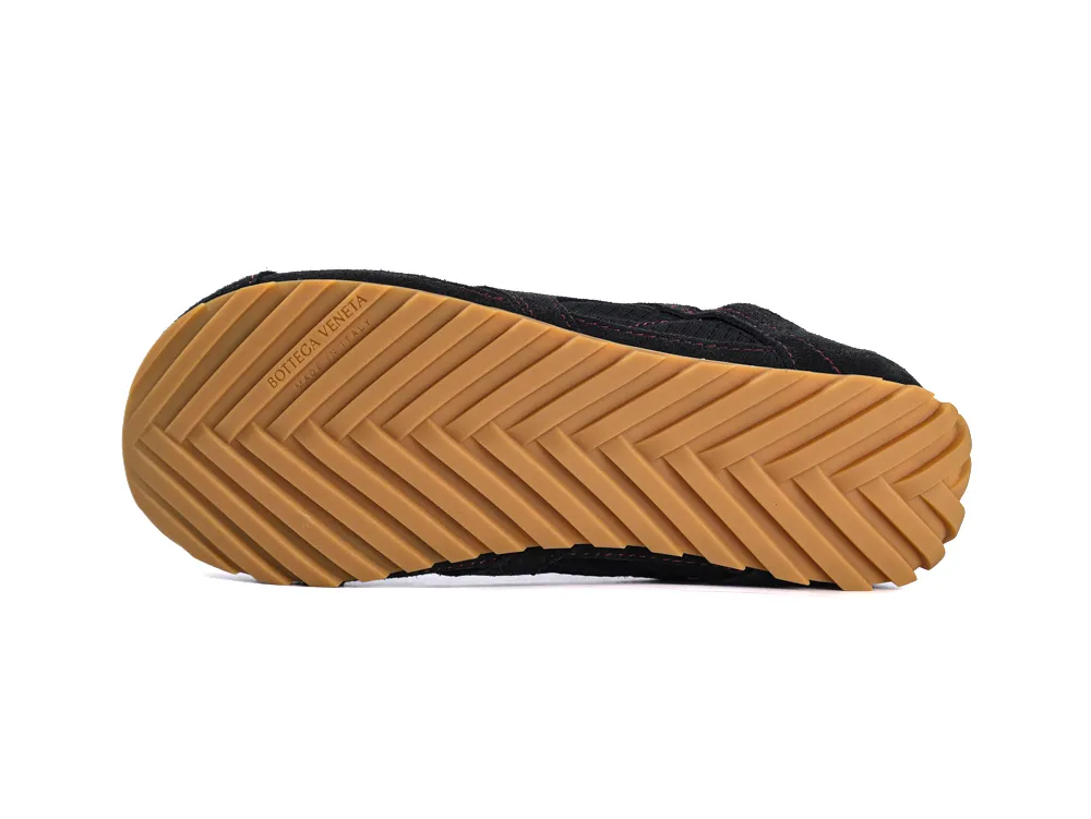 Black shoe with tan rubber sole, featuring a herringbone pattern for grip.