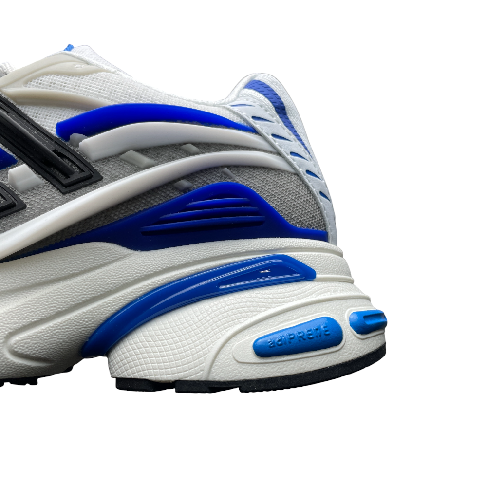 Close-up of a sneaker with layered materials, featuring textured white and gray surfaces, and bold black and blue accents.