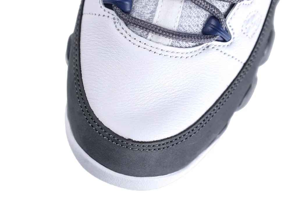 Close-up of a sneaker's gray suede toe cap and white leather upper.