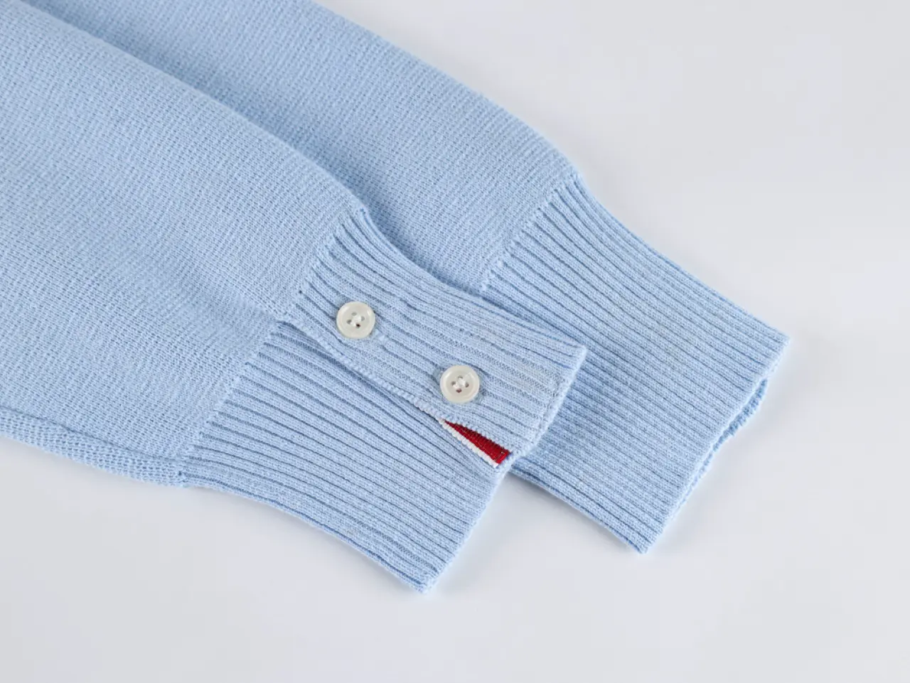 A front view of the sleeve and buttons, showcasing the soft brushed blue wool material