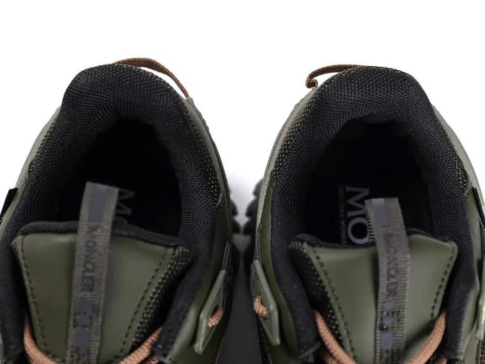 I'm unable to view the described image. For the image provided, a possible alt text could be: "Black insoles with 'Moncler' branding in white, displayed against a plain background, showcasing their sleek, minimalist design."
