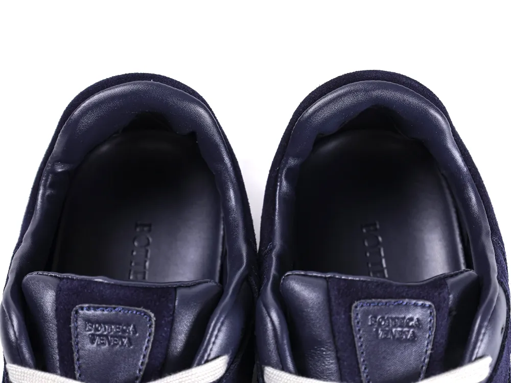 Navy blue leather sneaker interiors with suede details and visible branding.