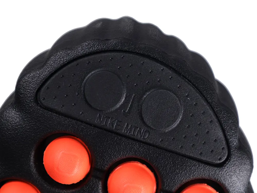 Black plastic grip with orange rubber buttons, featuring textured details and embossed label.