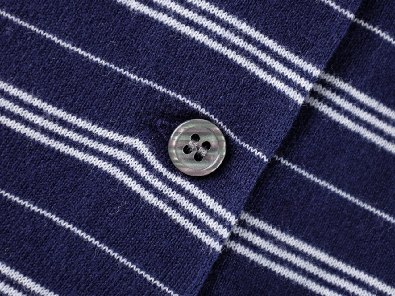 Close-up of a blue and white striped fabric with a button detail.