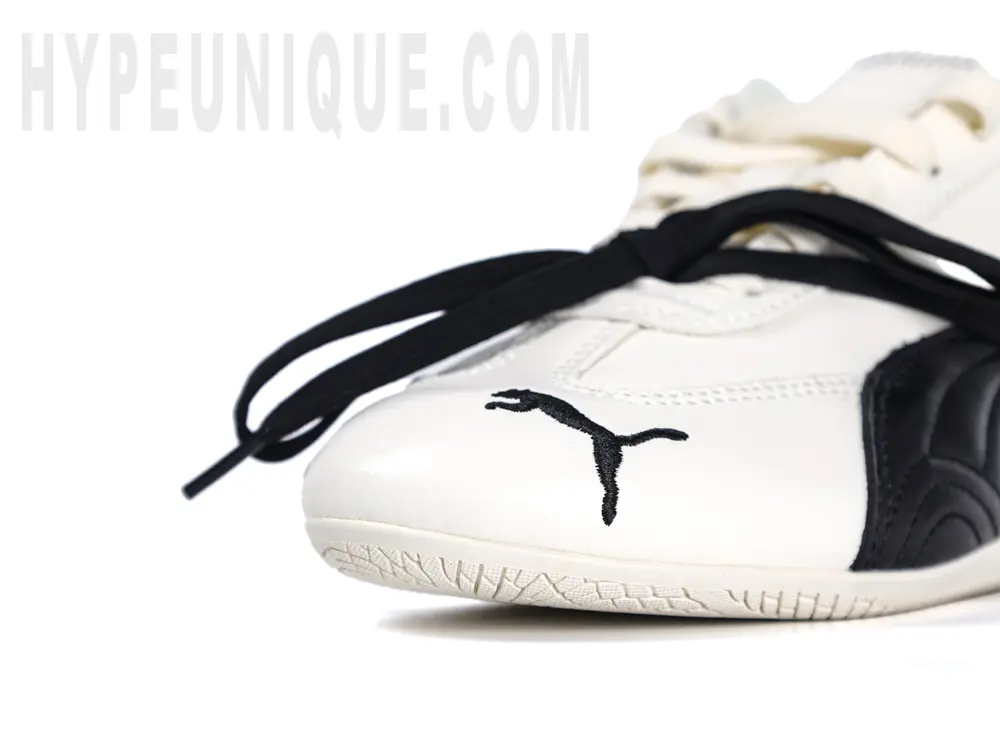 A close-up view of the right front of the off-white toe box, showing the white material and black embroidered brand logo.