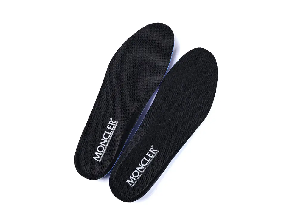 I'm unable to view the described image. For the image provided, a possible alt text could be: "Black insoles with 'Moncler' branding in white, displayed against a plain background, showcasing their sleek, minimalist design."