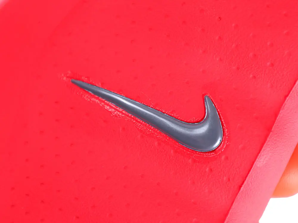 Close-up of red textured material with a gray logo.