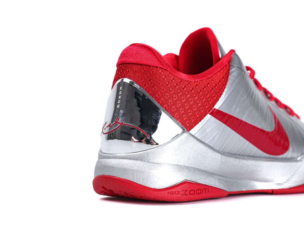 Red and silver sneaker with textured fabric and reflective metallic heel accent.