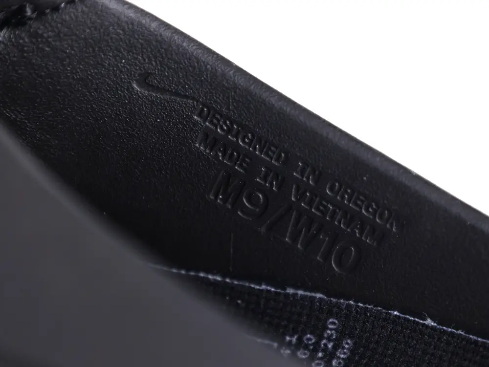 Black leather shoe interior with embossed text: "Designed in Oregon, Made in Vietnam."
