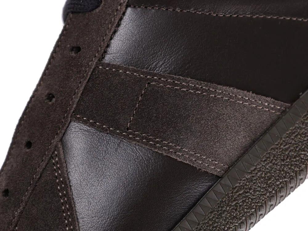 Close-up of a brown leather and suede sneaker with textured sole.