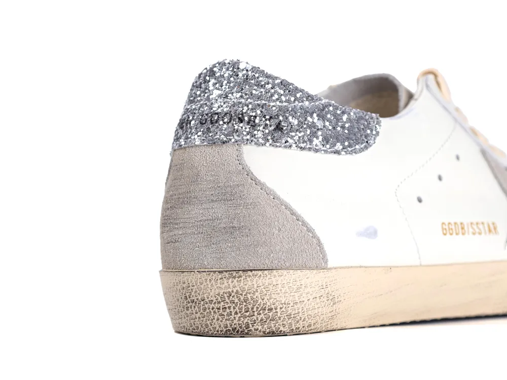 Close-up of silver glitter heel tab and grey suede on Golden Goose sneaker