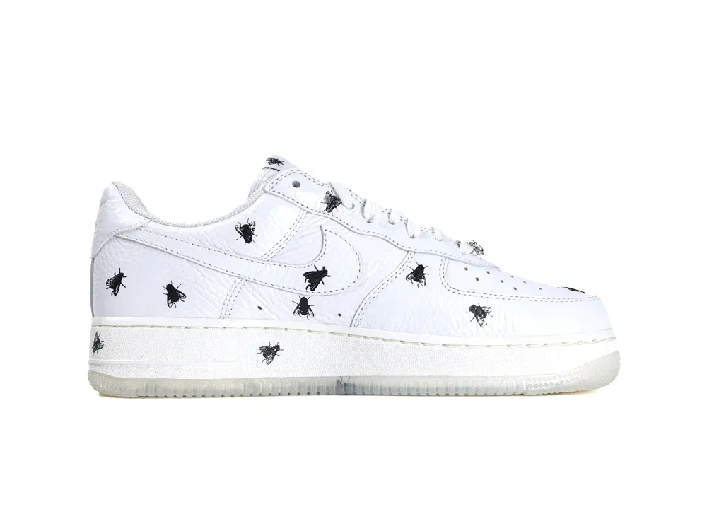 White leather sneaker with black fly pattern, featuring textured upper and rubber sole.