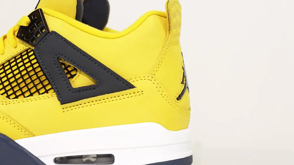 A rear view of the heel on the Jordan 4 Retro ‘Lightning’ (2021), featuring yellow suede material and a black Jumpman logo