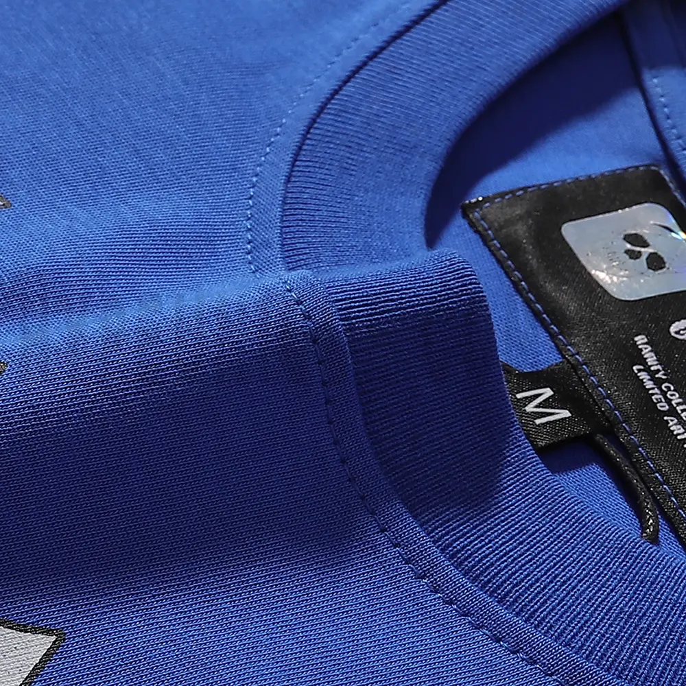 Detailed close-up of the tee's neck label, featuring wash care instructions and subtle brand branding in a clean, minimalist typography