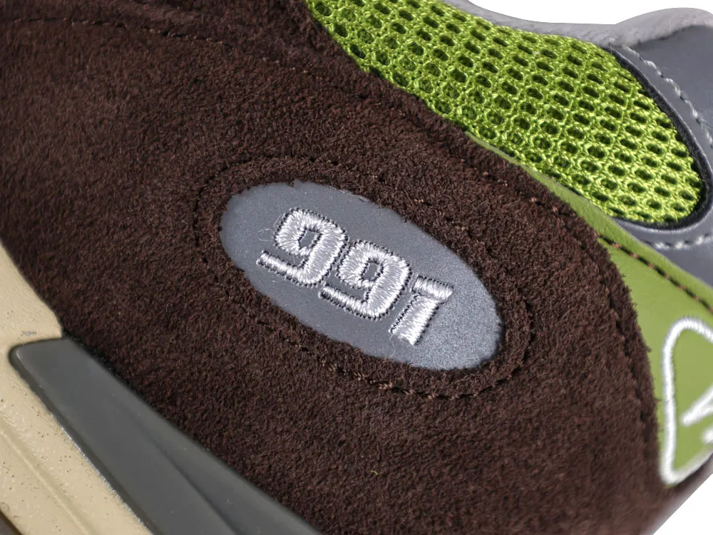 Brown suede heel with green mesh detail, gray patch, and embroidered "991".