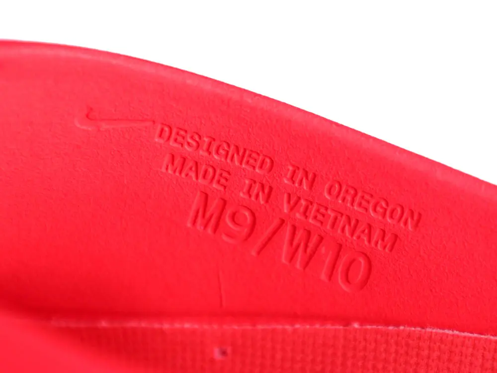 Close-up of a red rubber shoe sole with embossed text.