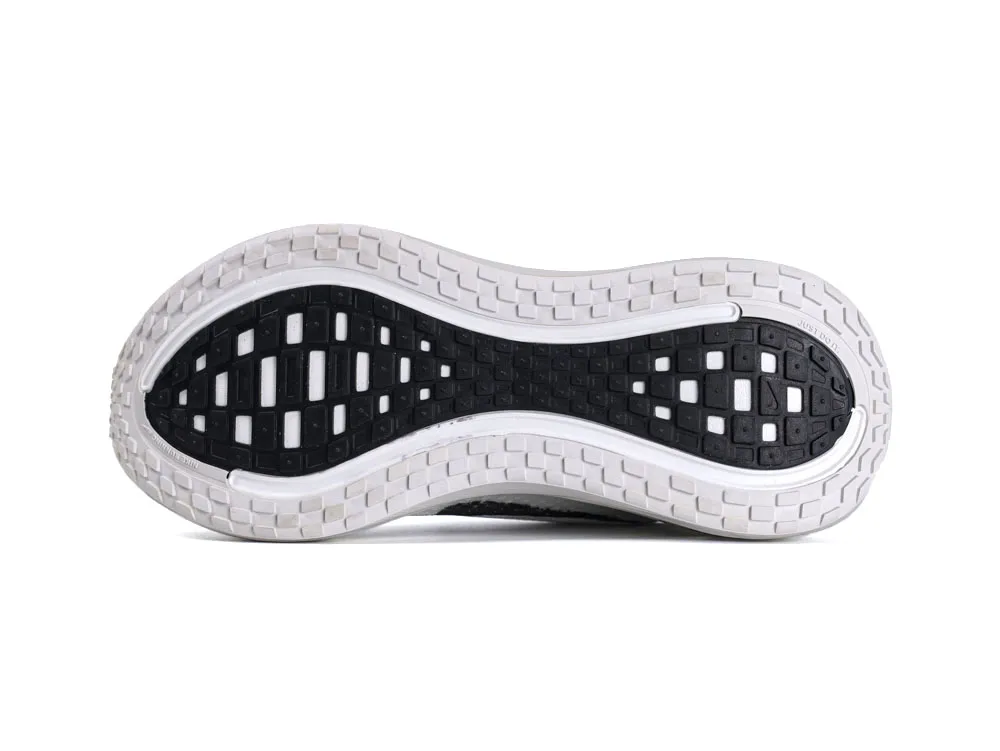 Black and white rubber sneaker sole with textured grip pattern, detailed design.