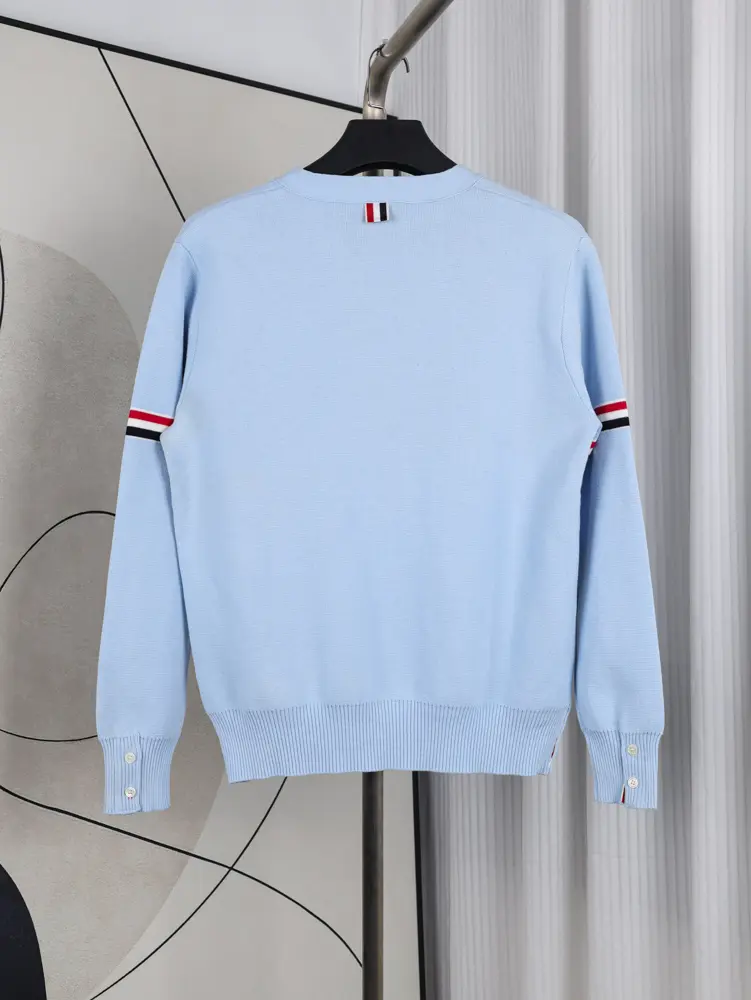 A back view of the Fine Merino Wool RWB Armband Cardigan in lright blue, showcasing its deep light blue merino wool material and design.