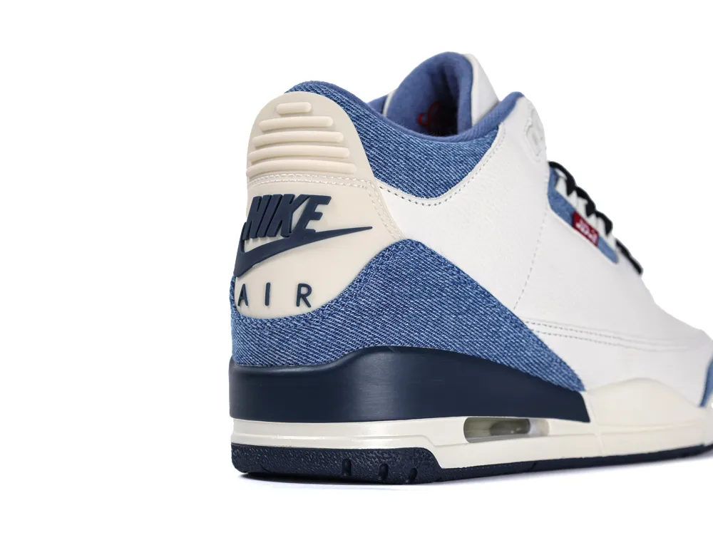 Close-up of the heel featuring an off-white tab with a navy blue Nike Air logo, surrounded by blue denim material.