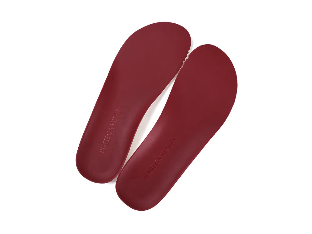 Red leather shoe insoles with brand imprint, designed for comfort and support.