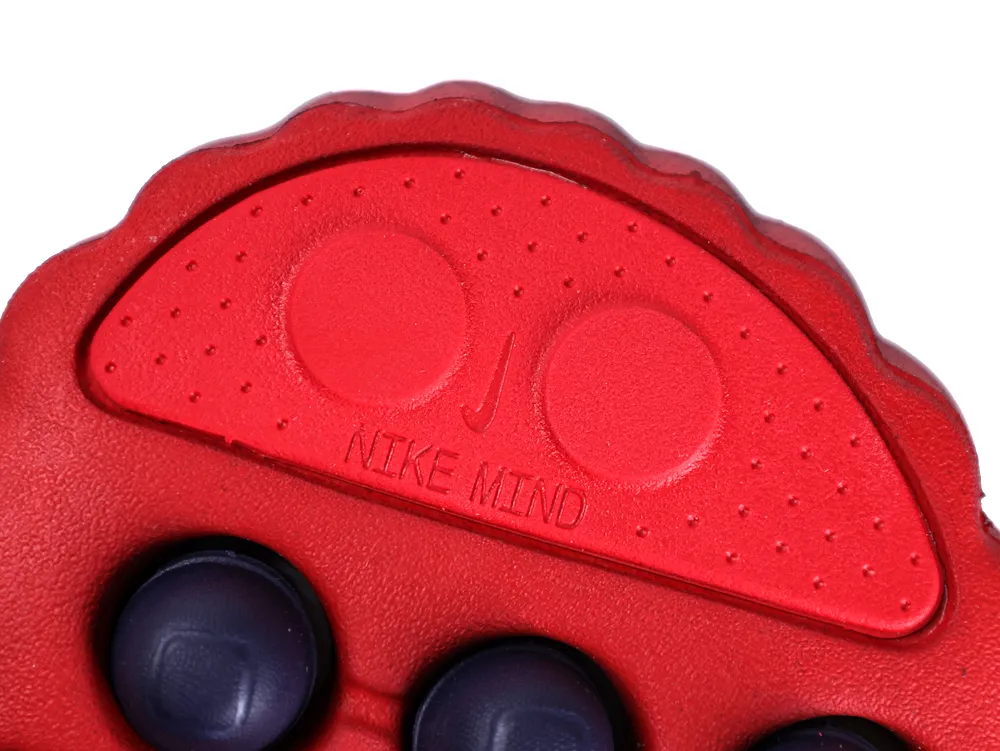Close-up of the bright red outsole toe area with "NIKE MIND" embossed text.